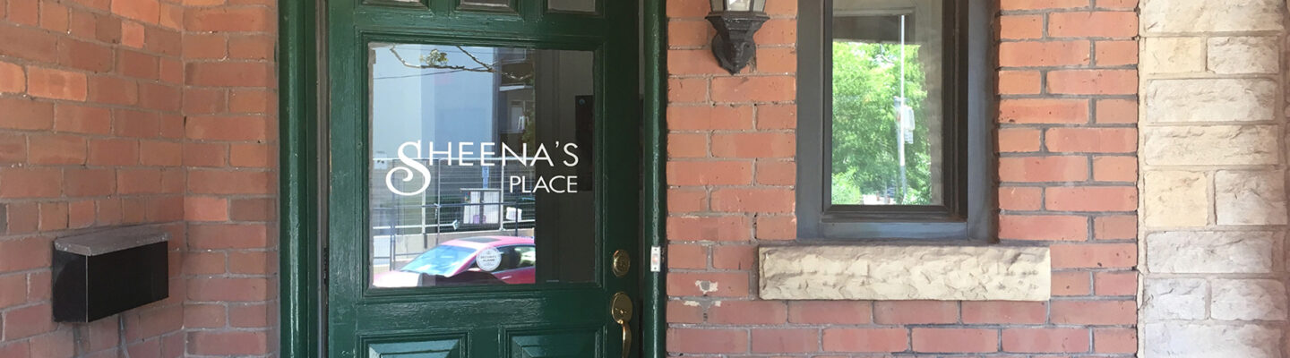 Front of Sheena's Place - red brick wall with green door